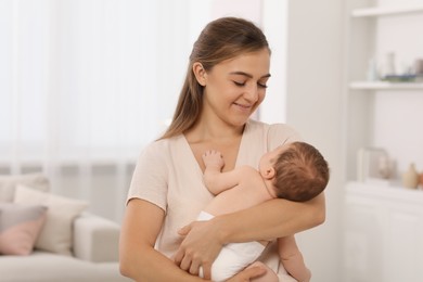 Mother holding her cute newborn baby at home