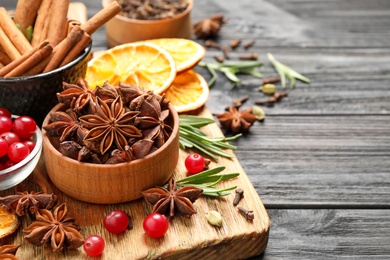 Composition with mulled wine ingredients on black wooden table, closeup. Space for text