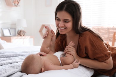 Mother with her cute baby on bed at home