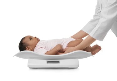 Doctor weighting African-American baby on scales against white background