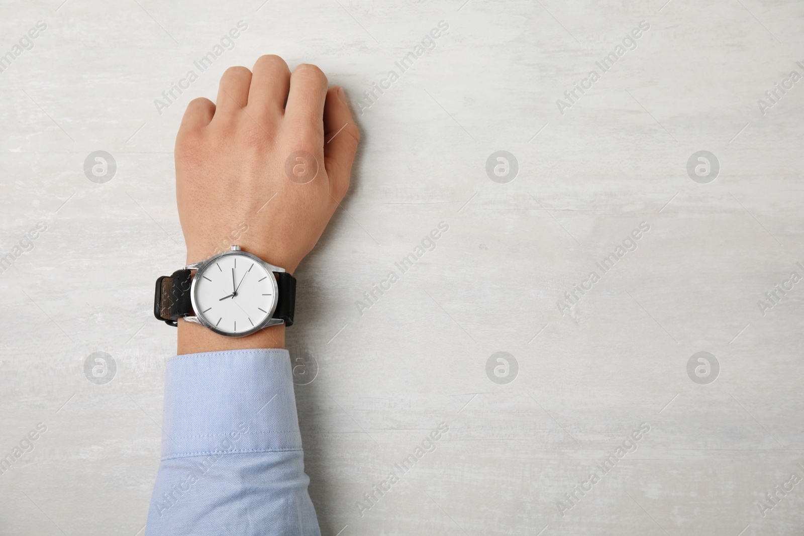 Photo of Man with stylish wrist watch at table, space for text. Time management