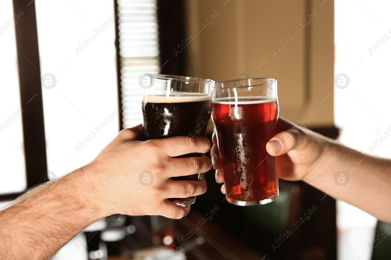 Photo of Friends clinking glasses with beer in pub