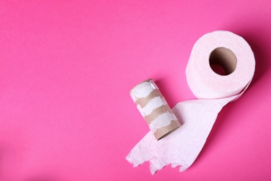 Photo of Toilet paper roll and empty tube on color background. Space for text