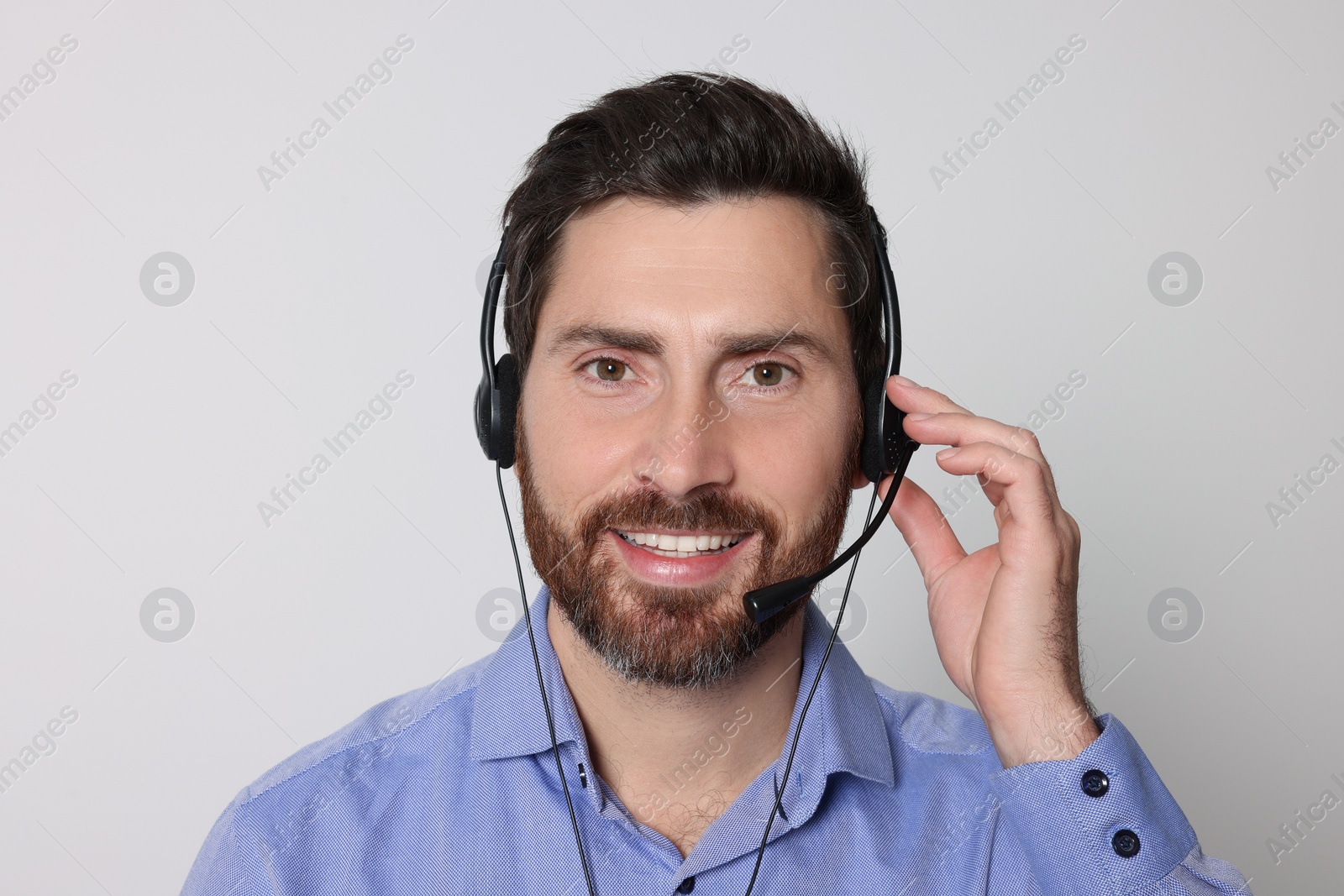 Photo of Hotline operator with headset on light grey background