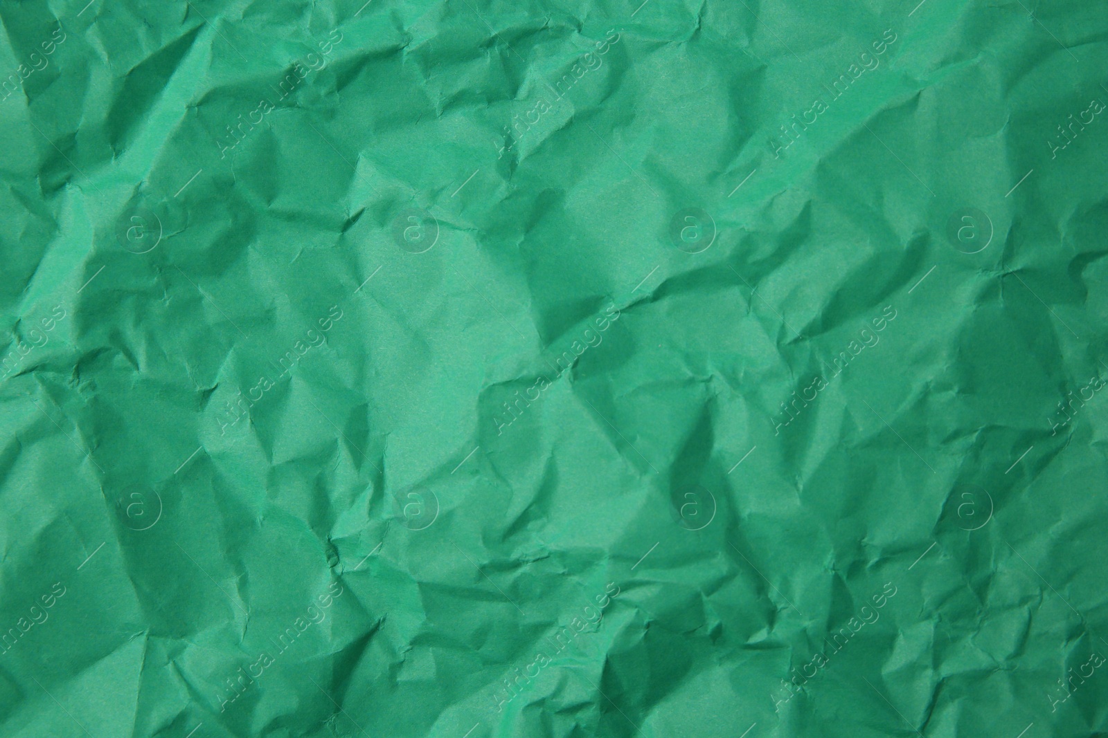 Photo of Sheet of crumpled green paper as background, top view