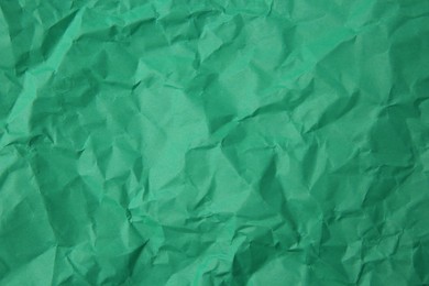 Sheet of crumpled green paper as background, top view