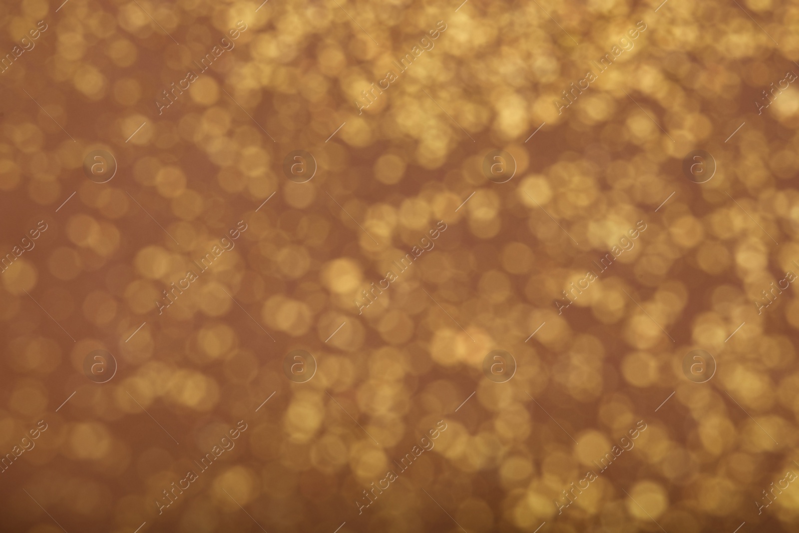 Photo of Blurred view of golden glitter on dusty rose background. Bokeh effect