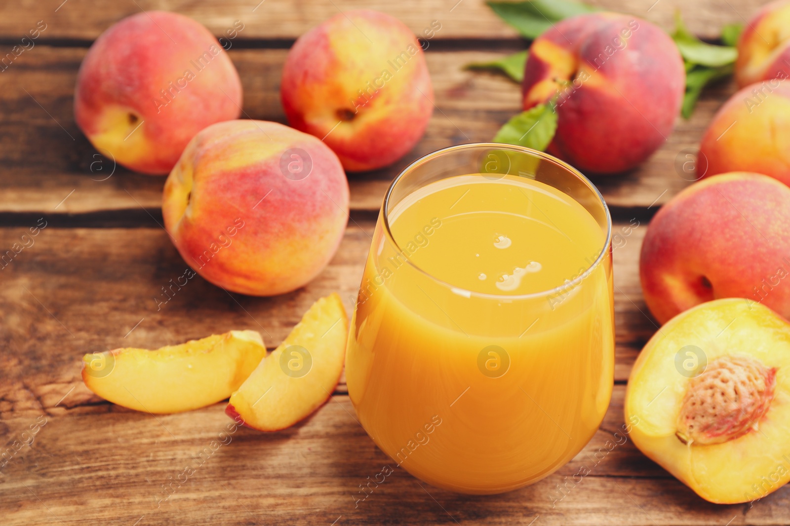 Photo of Natural peach juice and fresh fruits on wooden table