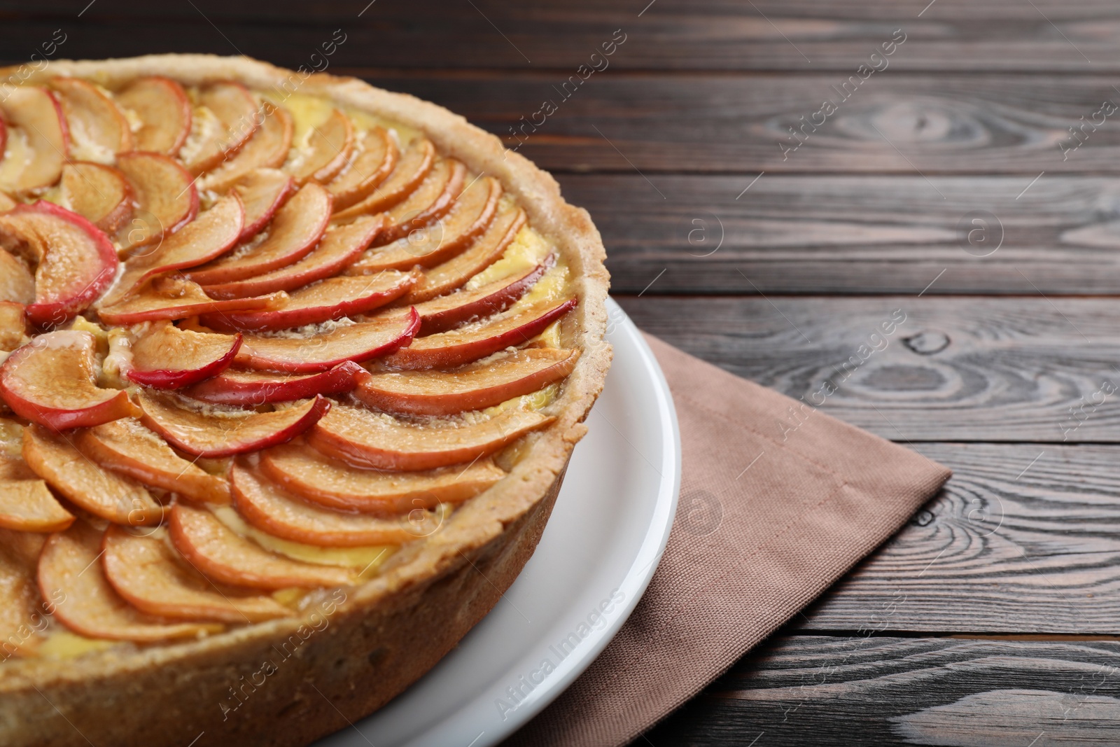 Photo of Freshly baked delicious apple pie on wooden table, closeup