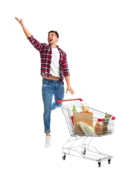 Young man with full shopping cart on white background