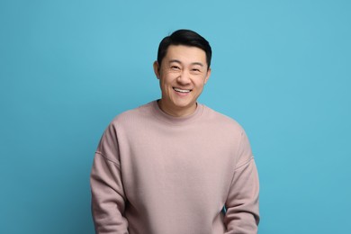 Photo of Portrait of happy man on light blue background