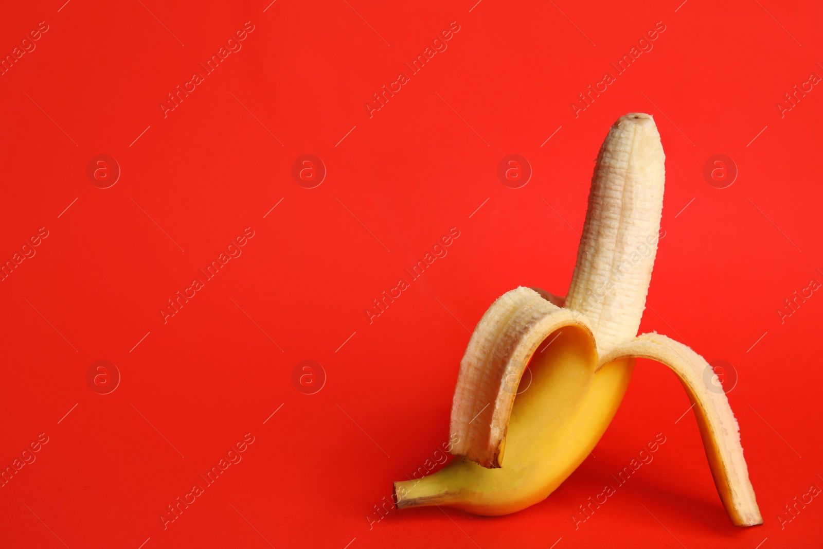 Photo of Fresh banana on red background, space for text. Sex concept