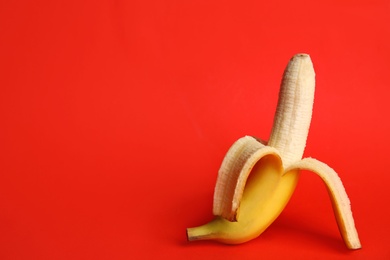 Photo of Fresh banana on red background, space for text. Sex concept