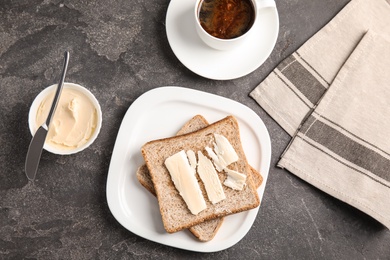 Photo of Flat lay composition with bread and butter served on grey table