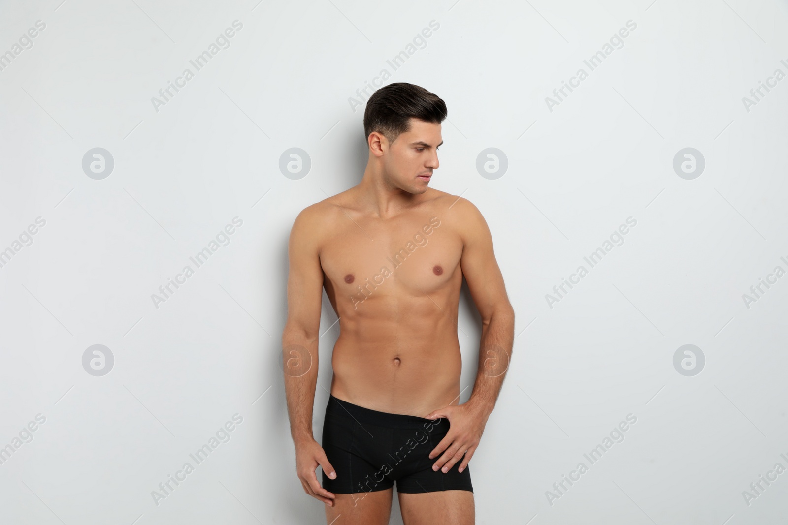 Photo of Handsome man in black underwear on white background