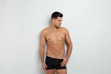 Handsome man in black underwear on white background