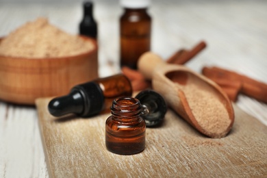 Photo of Bottle with cinnamon essential oil on wooden board