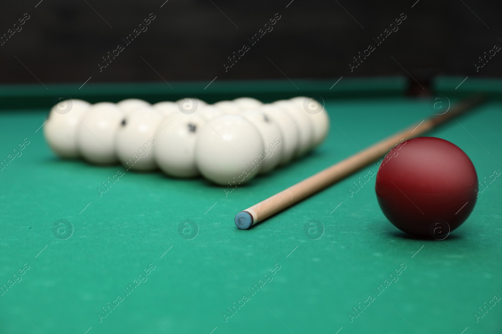 Photo of Billiard balls and cue on table indoors