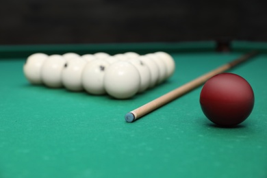 Photo of Billiard balls and cue on table indoors