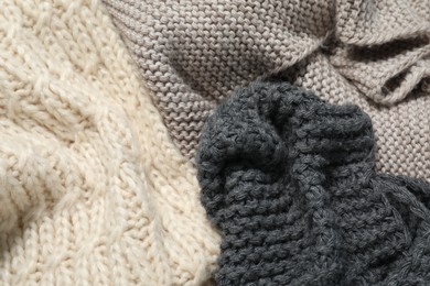 Photo of Stylish knitted scarfs as background, top view