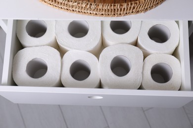 Many toilet paper rolls in white drawer indoors, top view