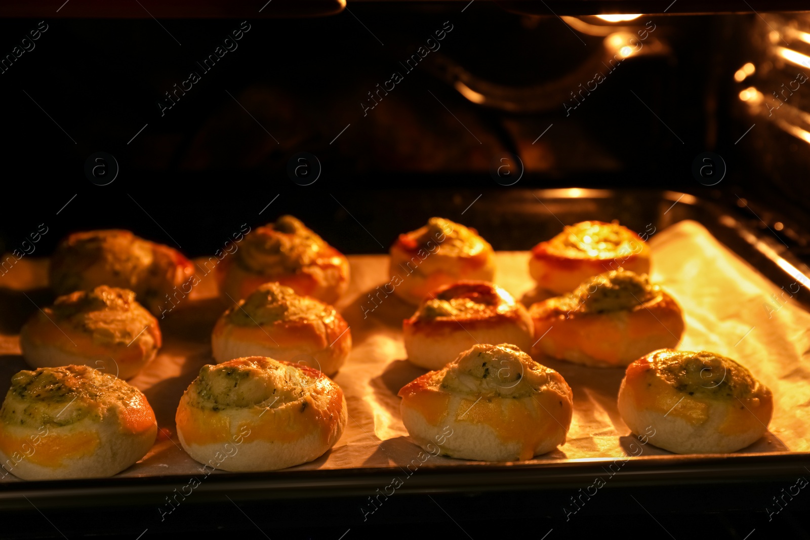 Photo of Baking puff pastry with tasty filling in oven, closeup