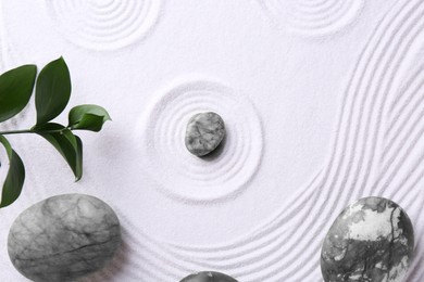 Photo of Zen concept. Stones, leaves and pattern on white sand, flat lay