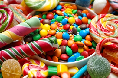 Photo of Many different yummy candies as background, closeup