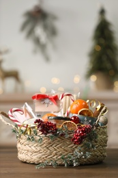 Wicker basket with Christmas gift set on wooden table