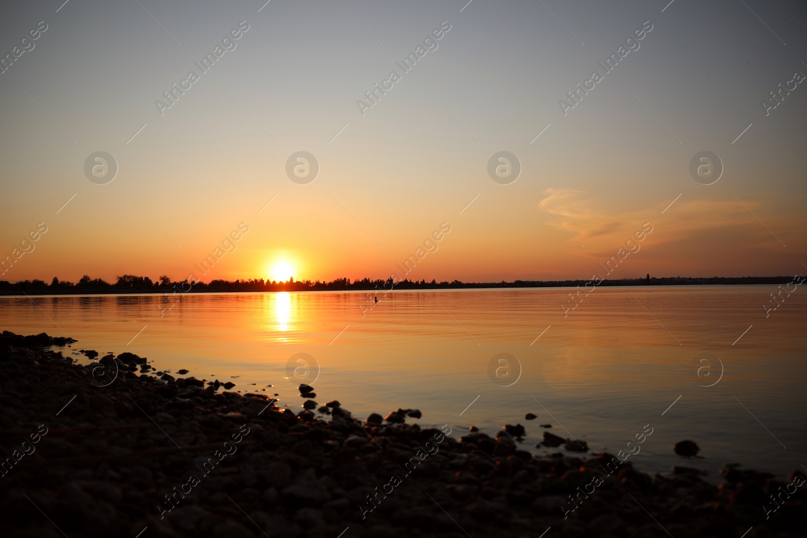 Photo of Picturesque view of rocky beach at sunset