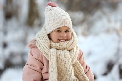 Photo of Portrait of cute little girl in snowy park on winter day