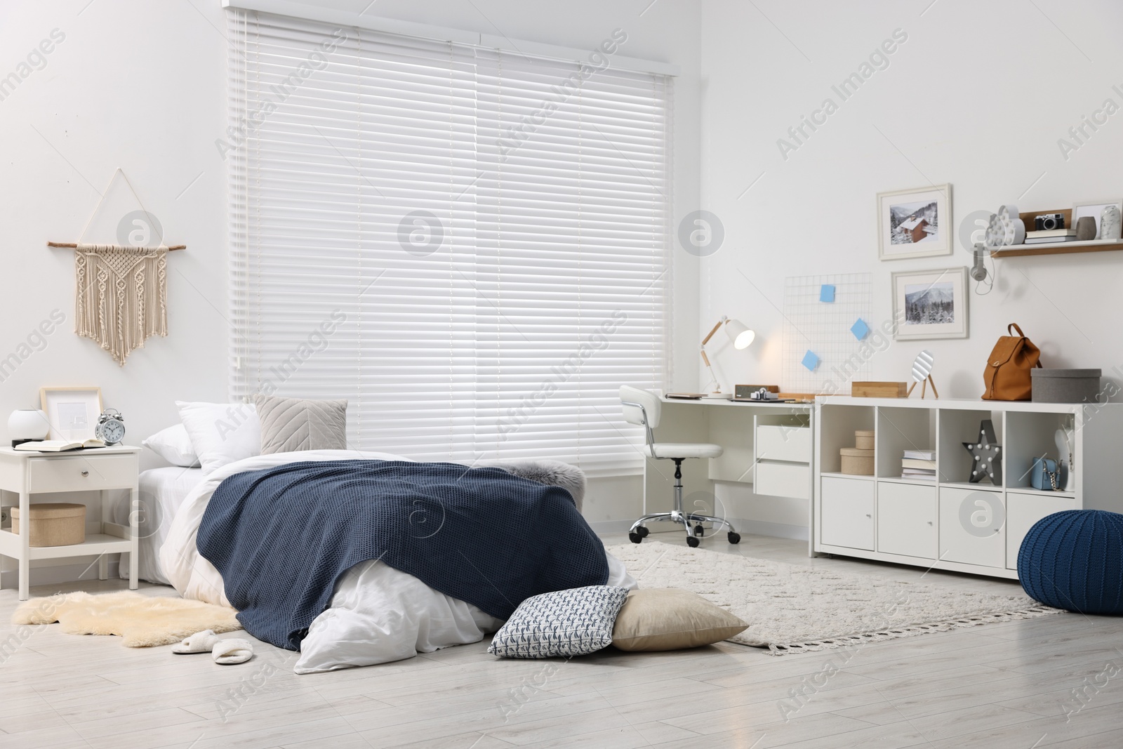 Photo of Bedroom interior with comfortable furniture, big window and white blinds