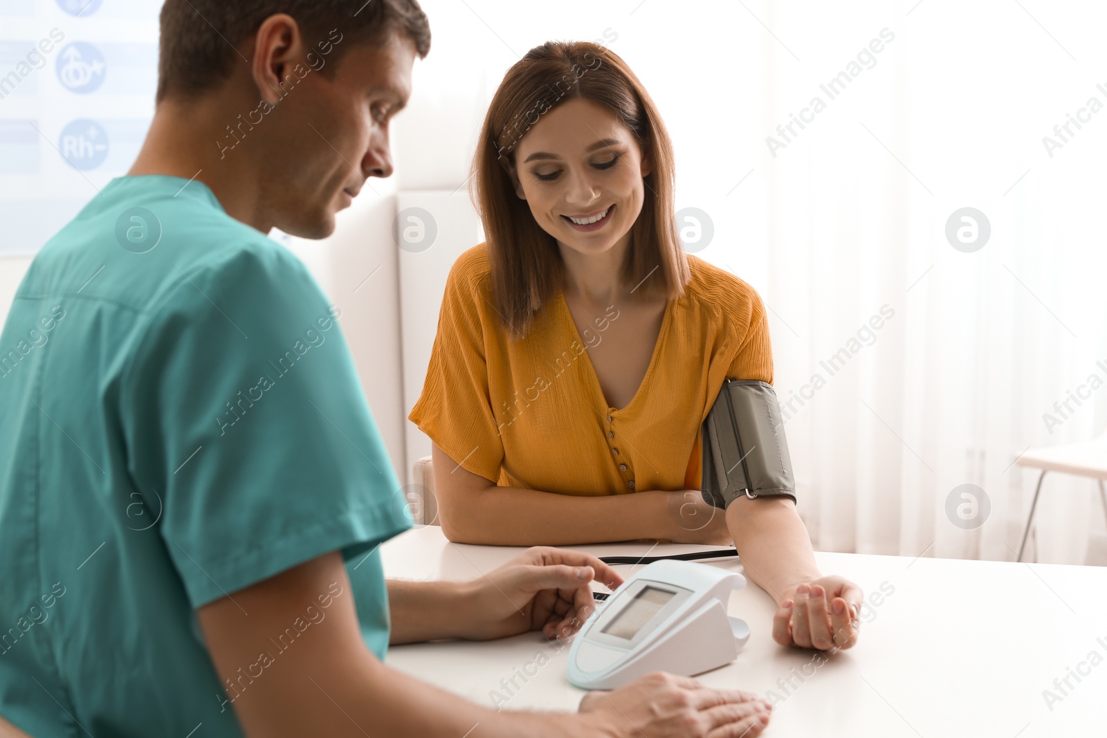 Photo of Doctor checking patient's blood pressure in hospital. Cardiology concept