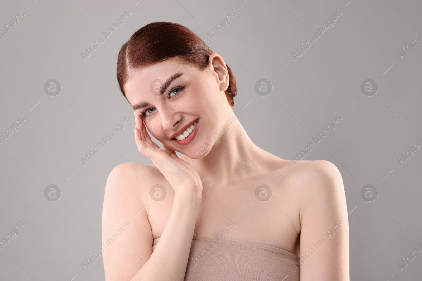 Photo of Portrait of smiling woman on grey background