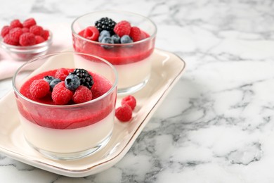 Photo of Delicious panna cotta with fruit coulis and fresh berries served on white marble table. Space for text