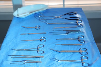 Photo of Different surgical instruments on blue table indoors