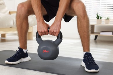 Photo of Man training with kettlebell at home, closeup
