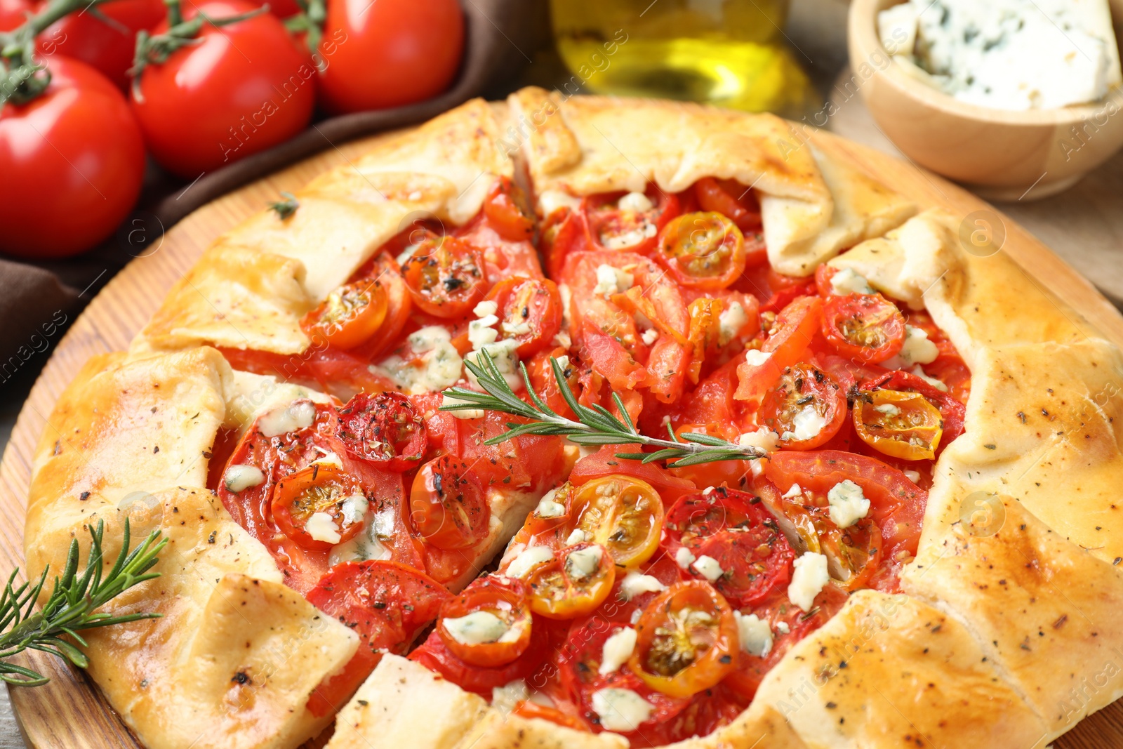 Photo of Tasty galette with tomato, rosemary and cheese (Caprese galette) on table, closeup