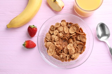 Flat lay composition with cornflakes on pink wooden table. Healthy breakfast