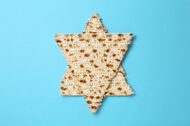 Star of David made with passover matzos on light blue background, top view
