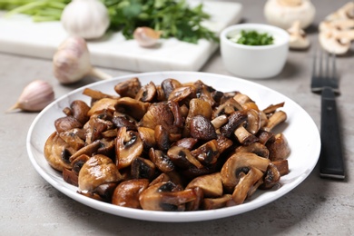 Photo of Plate of tasty fried mushrooms on table