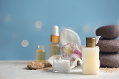 Beautiful composition with cosmetic products and spa stones on white table. Space for text