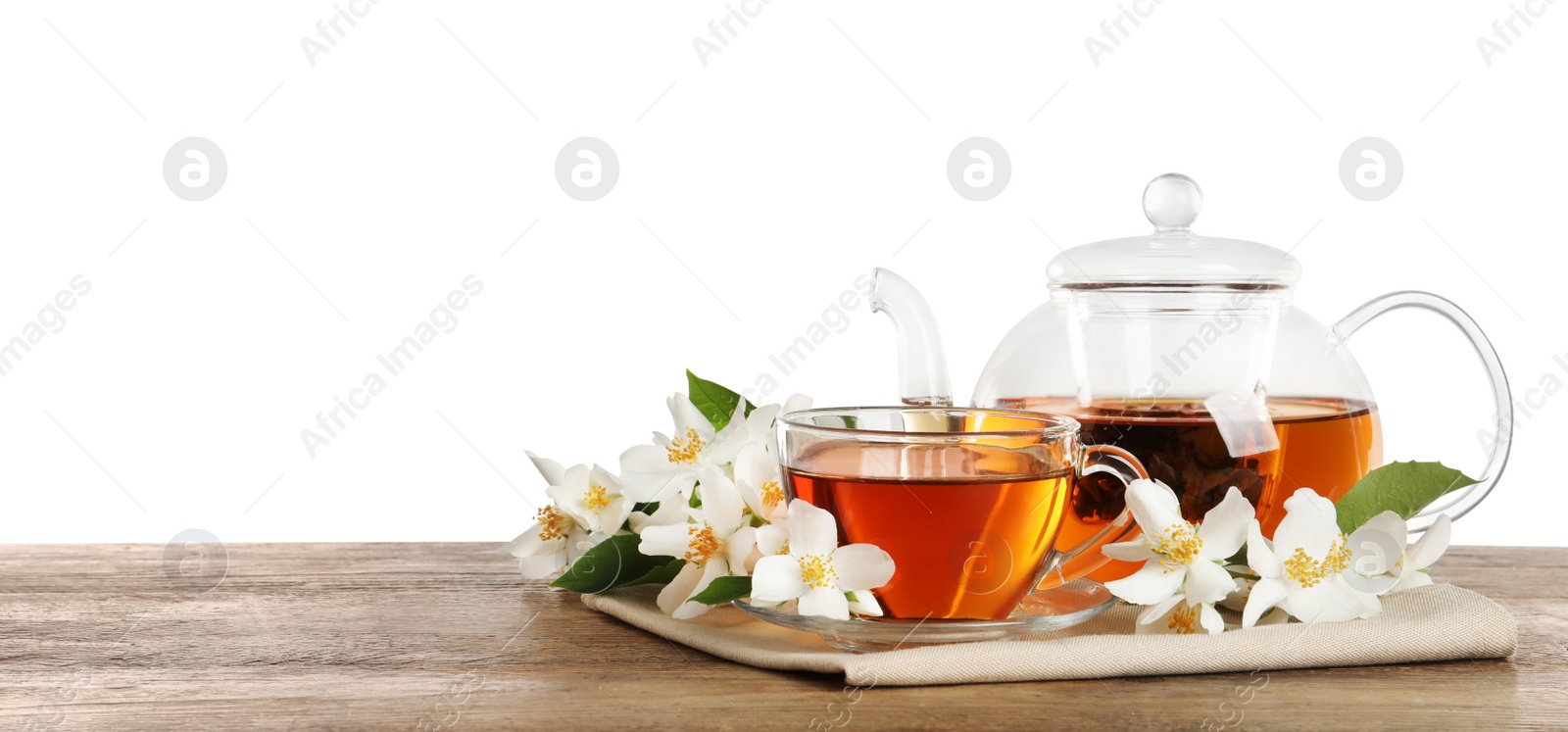 Photo of Aromatic jasmine tea and fresh flowers on wooden table against white background. Space for text