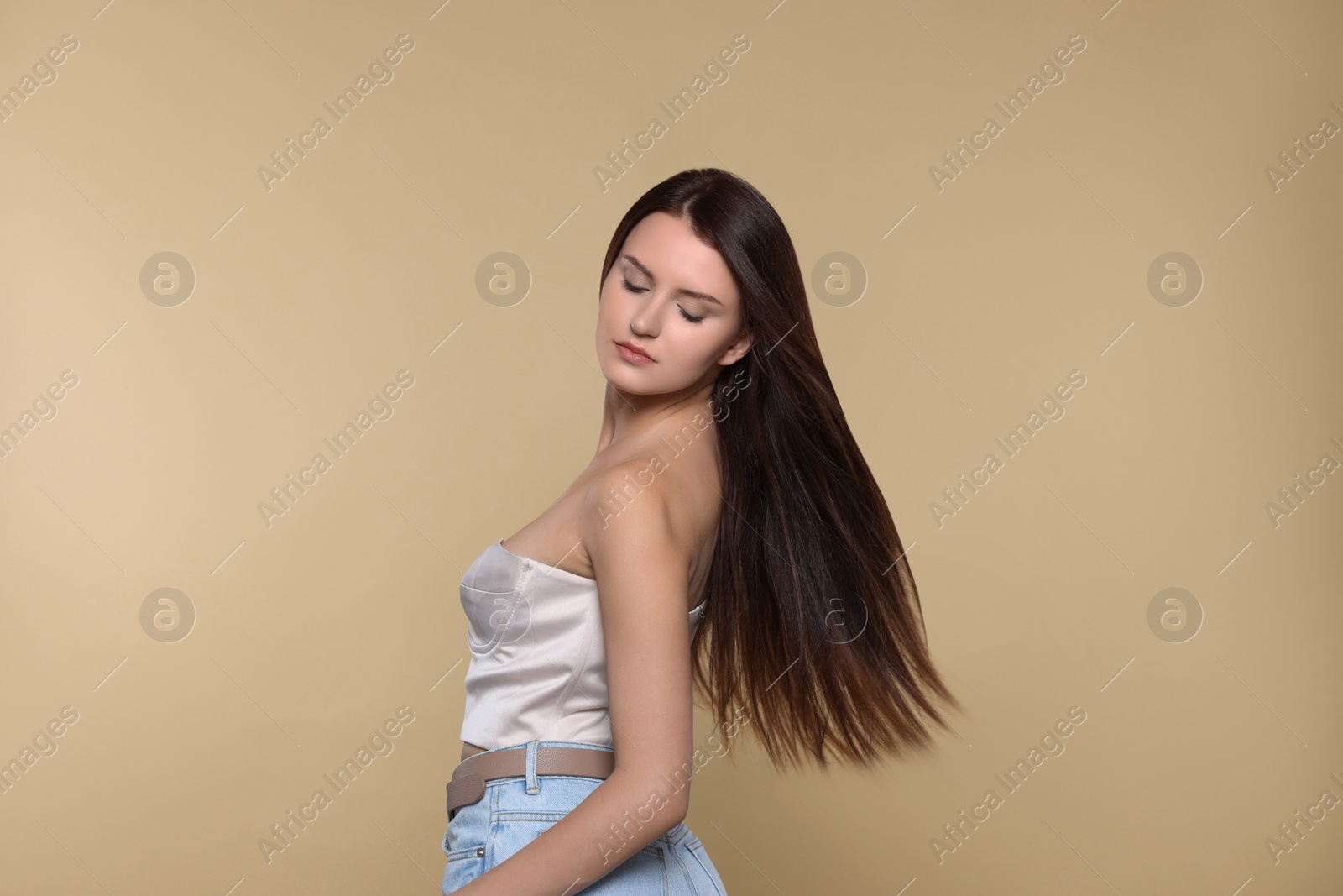 Photo of Portrait of beautiful young woman with healthy strong hair on beige background