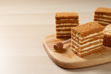 Photo of Delicious layered honey cake on wooden table. Space for text