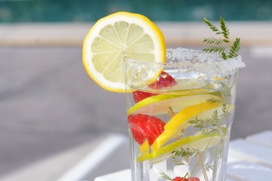 Photo of Delicious refreshing lemonade with raspberries outdoors, closeup. Space for text