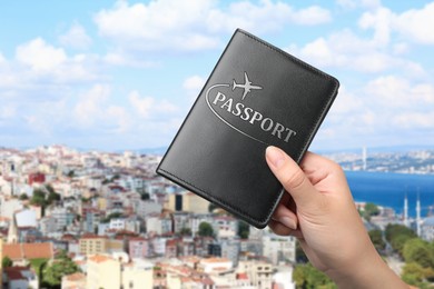 Image of Woman holding passport and beautiful view of city near sea on background