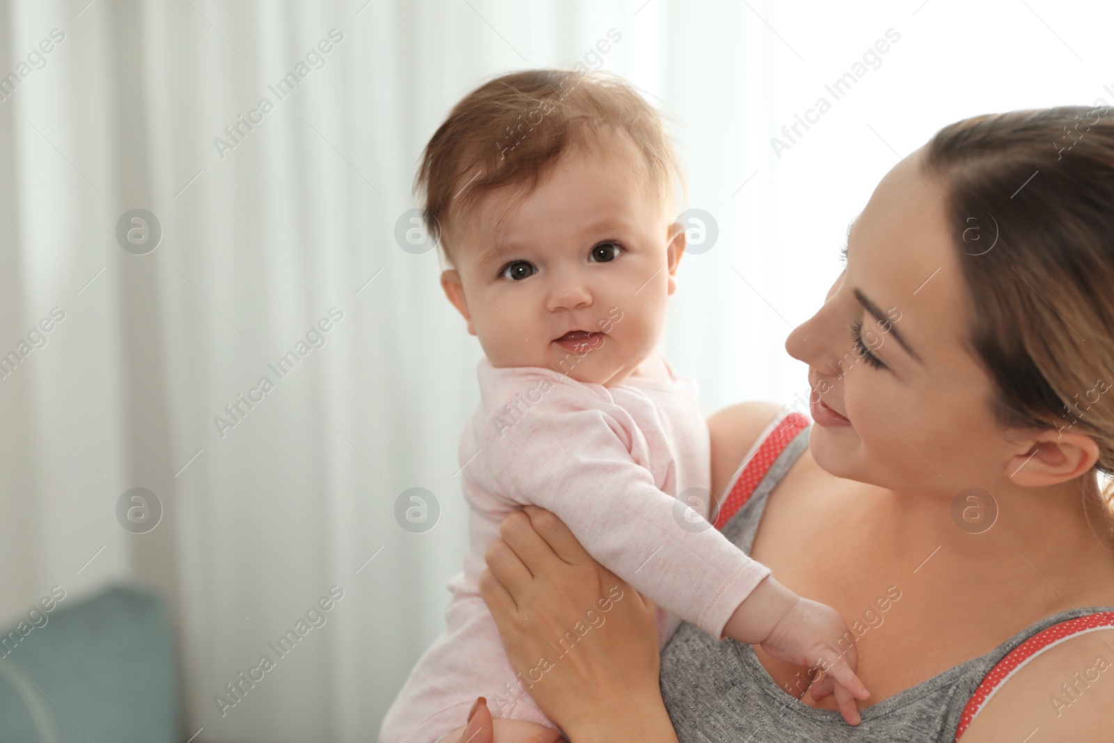 Photo of Young woman with her cute baby at home