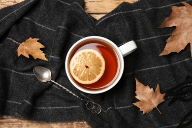 Flat lay composition with hot cozy drink, scarf and autumn leaves on table