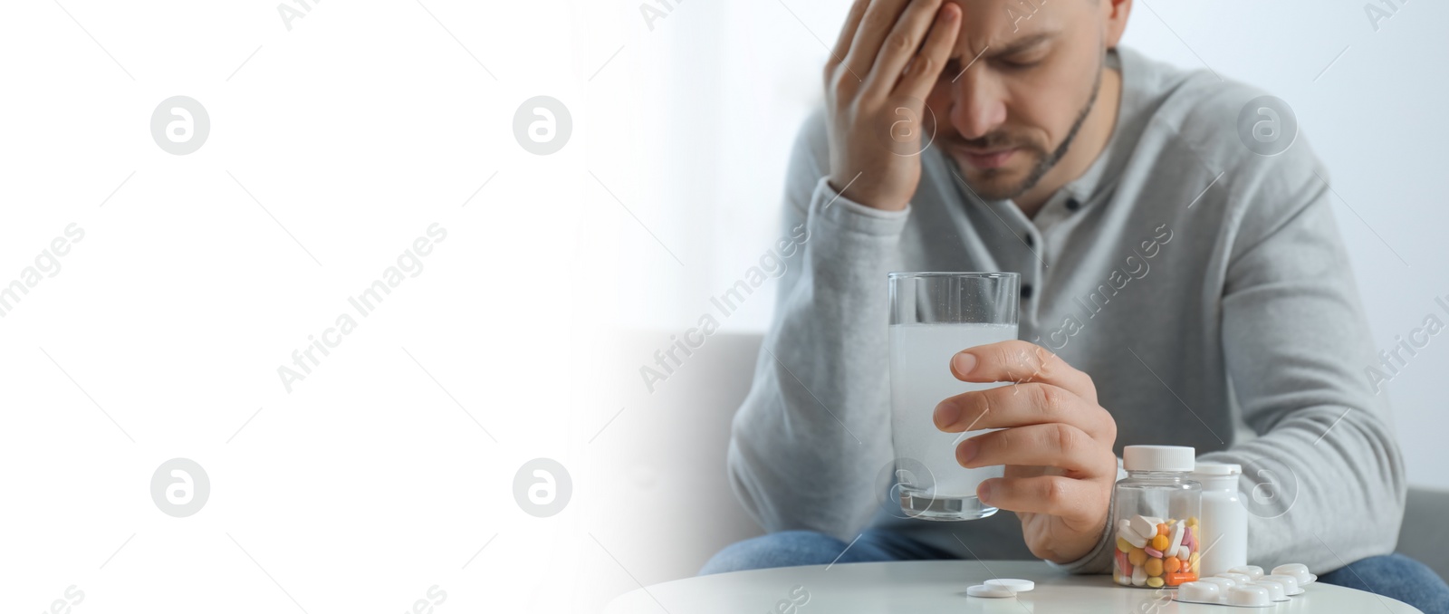 Image of Man holding glass of medicine for hangover at home, closeup. Banner with space for text